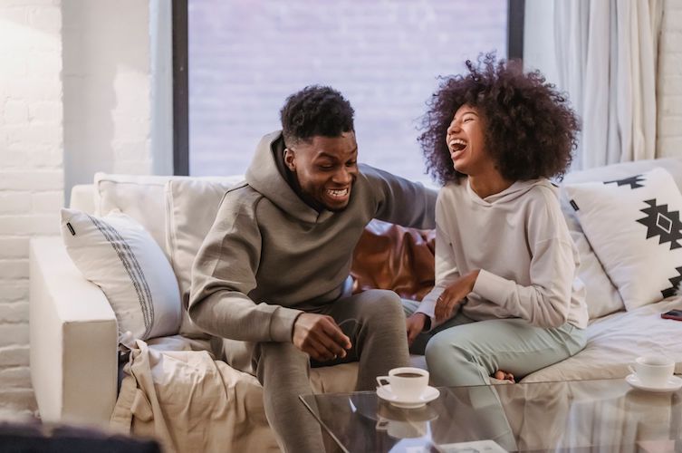 man and women sitting on couch laughing